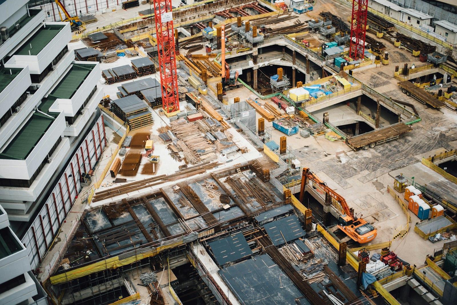 Aerial view of a dense building construction site with tower cranes